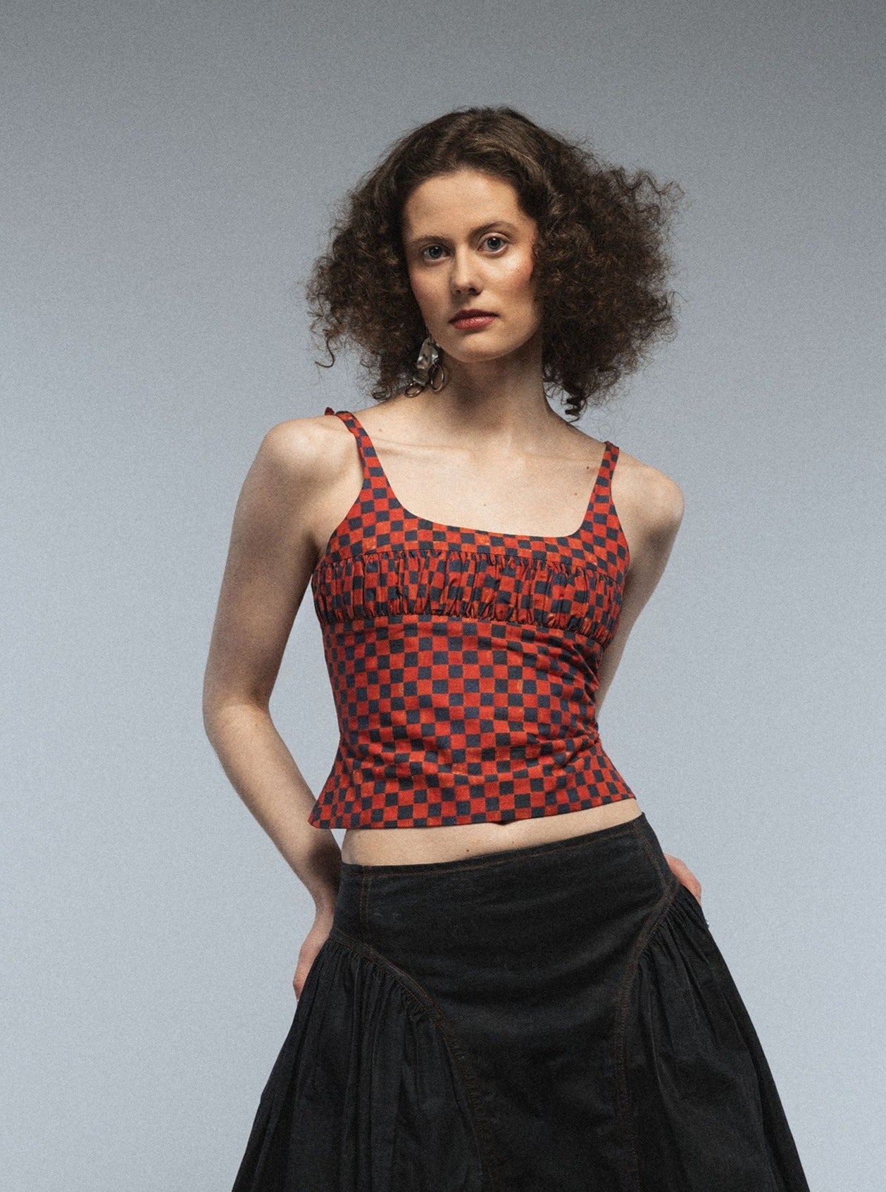 Red and Denim checkerboard pattern,which looks handpainted. This is made into a tight-fitting, adjustable top, which has bows in the back. the neckline is square and in the area of to breast there is a row of gathers